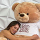 A woman affectionately hugs a top online gift choice, the Giant Teddy, reassured by its 30-Day Money Back Guarantee.